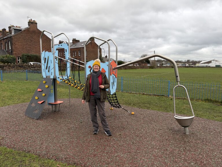 Cllr Susan Davies, Penrith Town Council West Ward Councillor at Castletown Play Area standing in front of the Little City Plus unit.